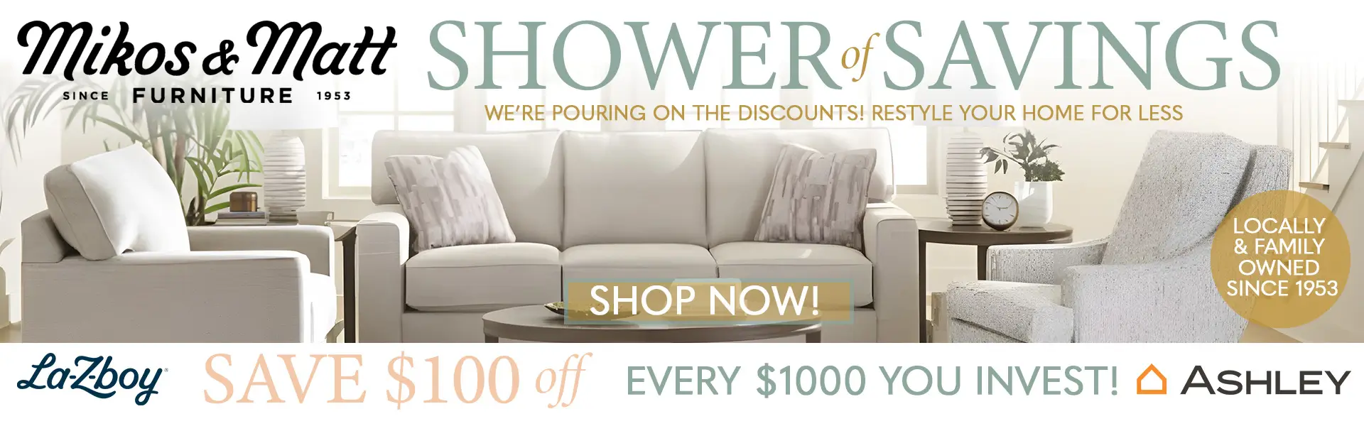 Promotional banner for Mikos & Matt Furniture's "Shower of Savings" sale. The background features a bright, neutral-toned living room with a white sofa, two matching armchairs, and a coffee table. The text reads, "We're pouring on the discounts! Restyle your home for less," above a "Shop Now!" button. A gold circle badge states, "Locally & family owned since 1953." A banner along the bottom includes La-Z-Boy and Ashley Furniture logos and advertises, "Save $100 off every $1000 you invest!"